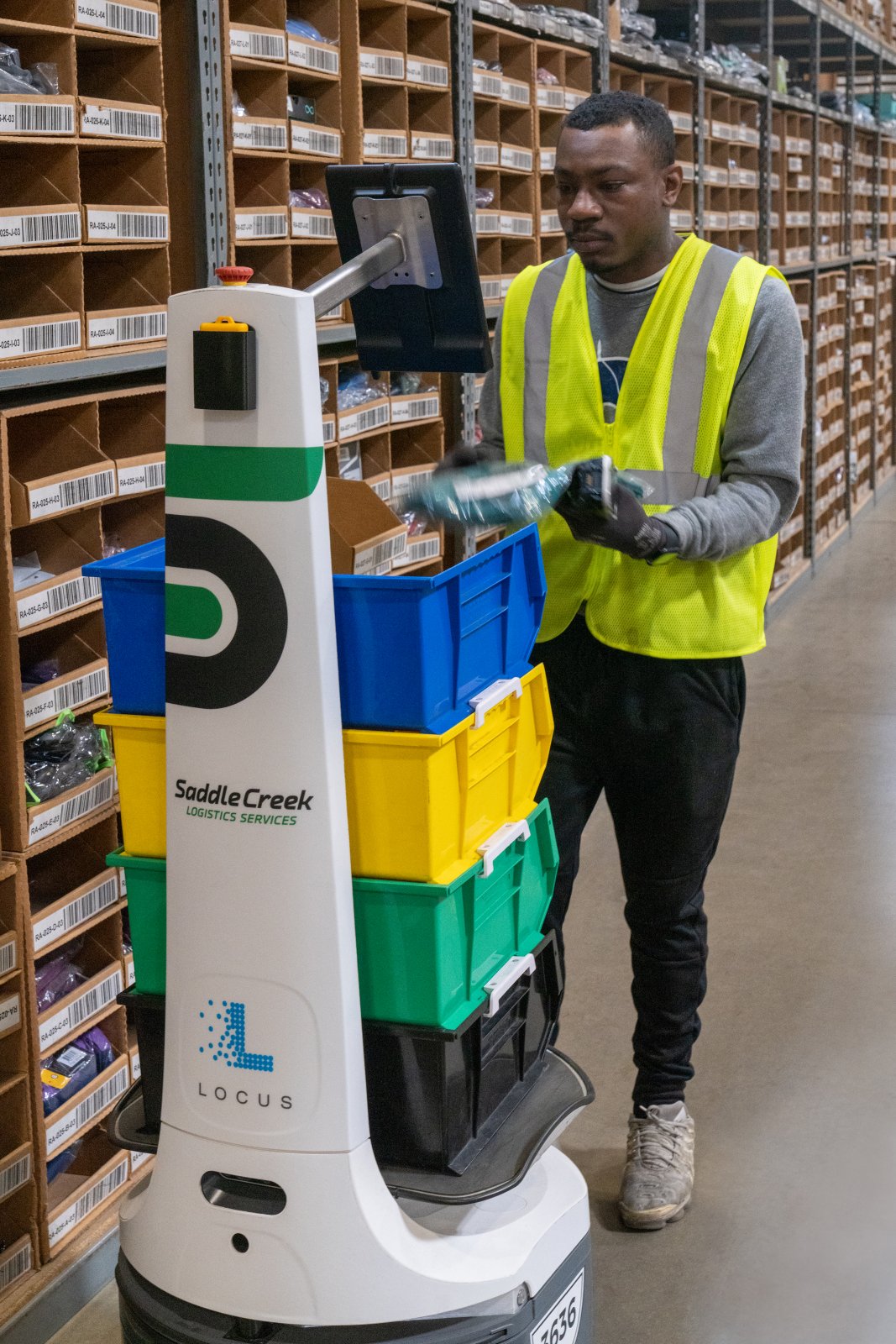Saddle Creek associate working beside a mobile warehouse robot