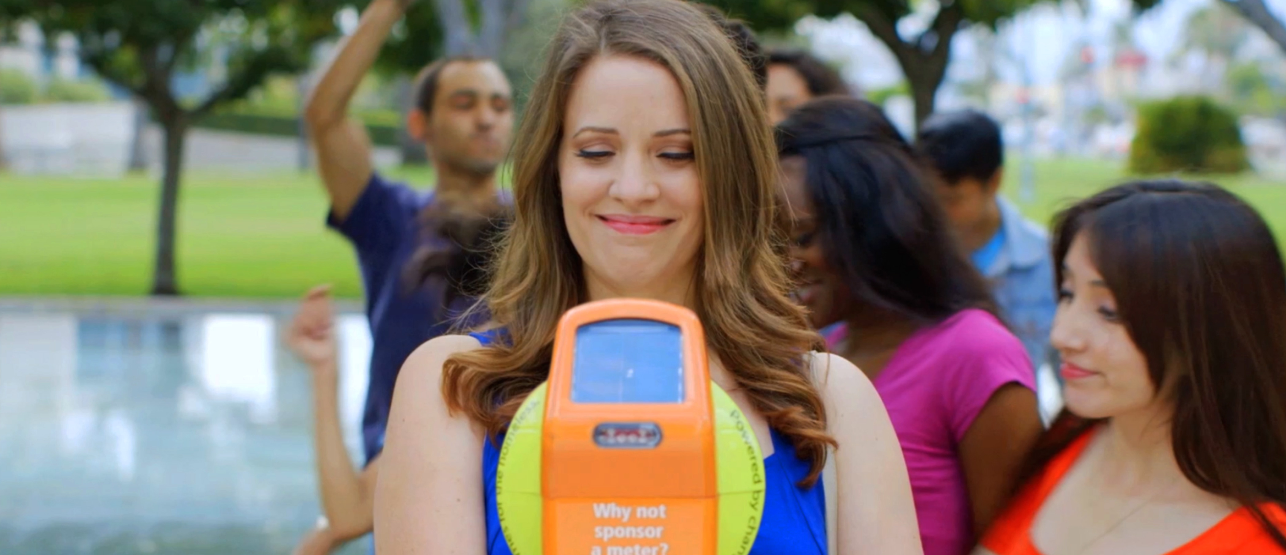 A woman using one of the orange donation meters created for Pasadena's Real Change Movement