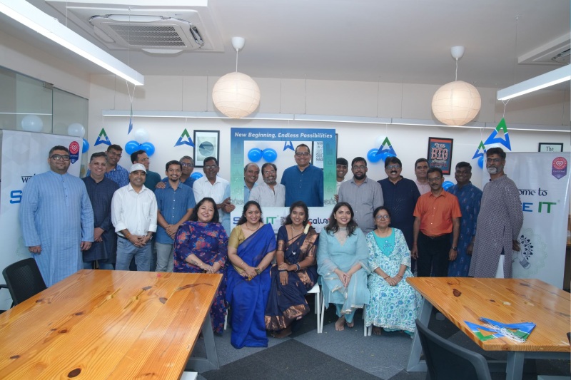 Sage IT employees gathered around meeting tables at the Bengaluru office opening