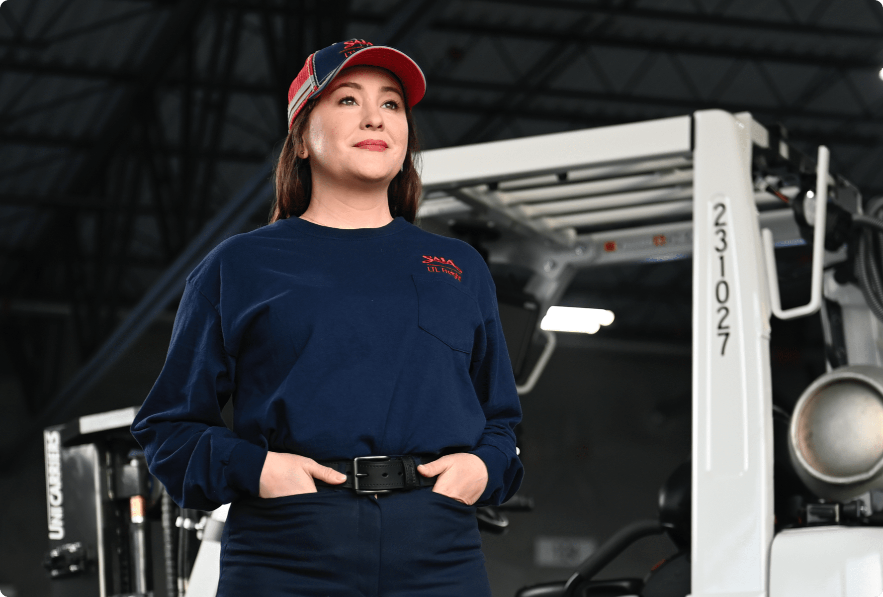 Saia employee standing beside a forklift in a freight facility