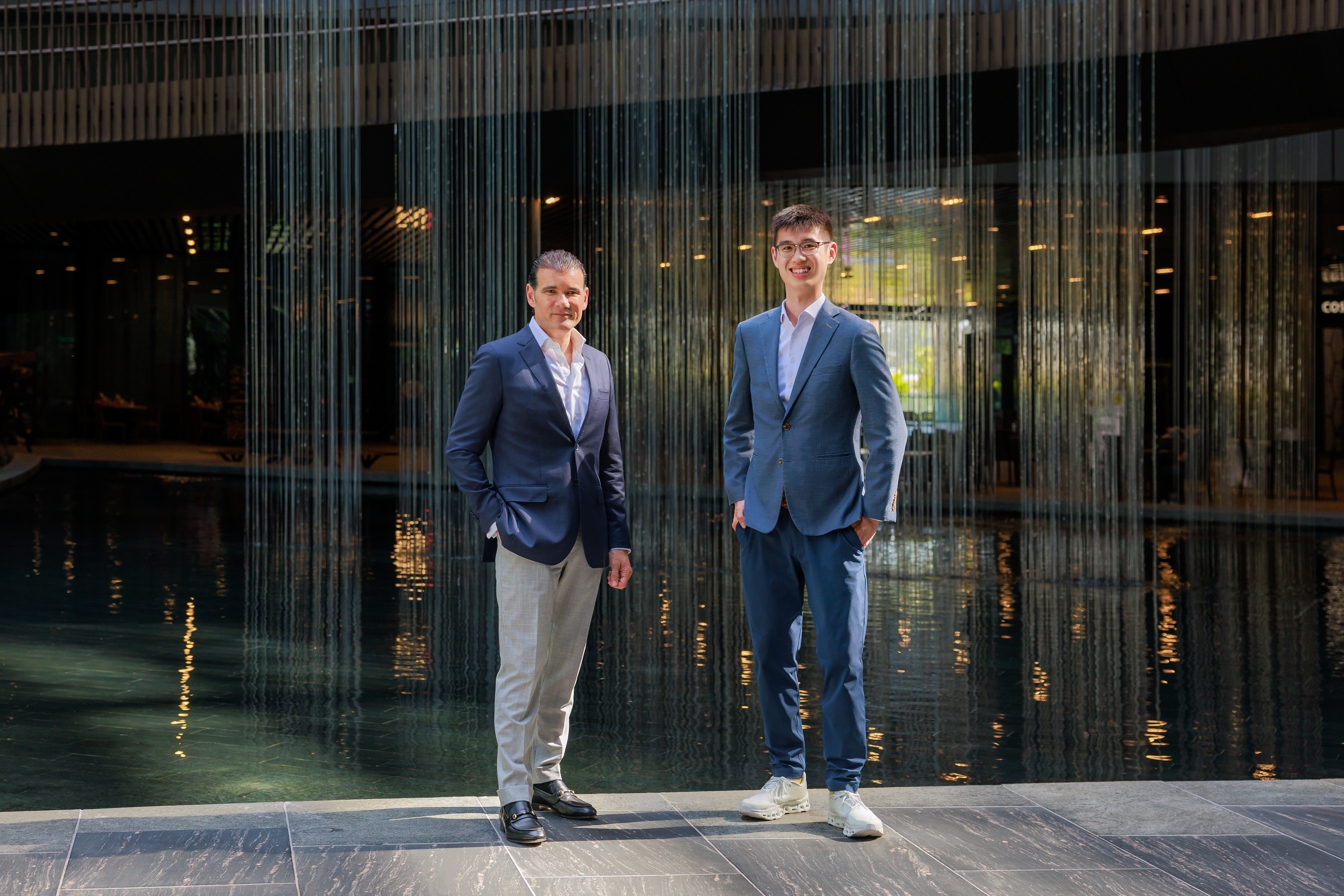 Hans de Back and Qin En Looi standing beside an indoor water feature
