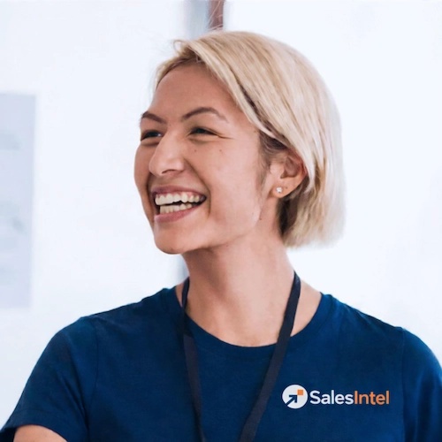 A smiling SalesIntel team member wearing a navy company shirt
