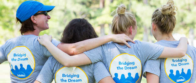 Four Sallie Mae employees wearing Bridging the Dream shirts