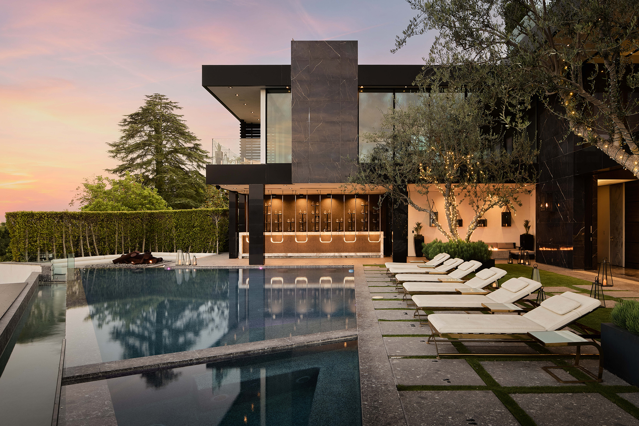 Pool, loungers and modern architecture at 1200 Bel Air Road at dusk
