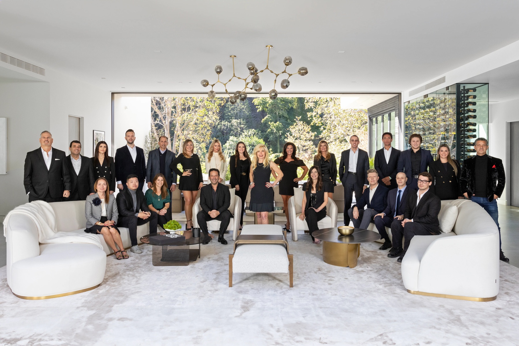Sally Forster Jones standing in the center of her team in a bright living room