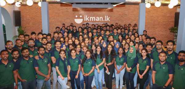 ikman staff assembled in their office wearing matching green shirts