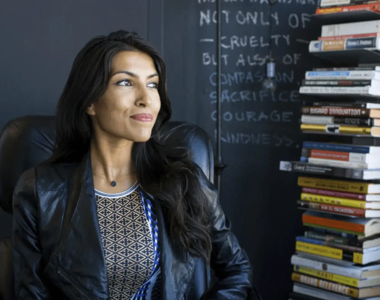 Sama founder Leila Janah seated beside a stack of books