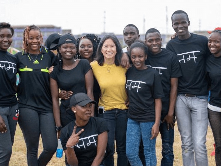 Leila Janah in a yellow shirt standing with a group of Sama team members