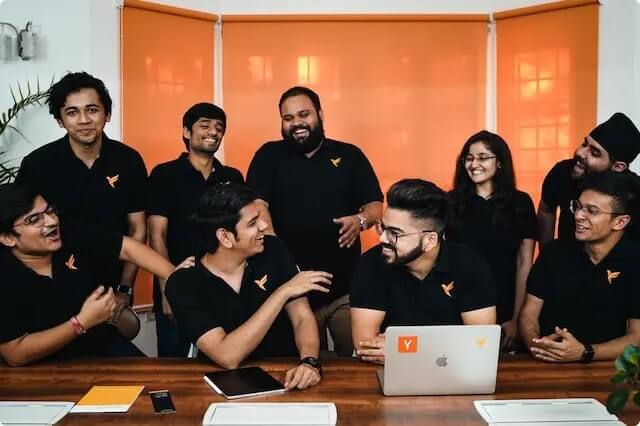 An early FamPay team gathered around a table, with Sambhav Jain seated at the front left of centre