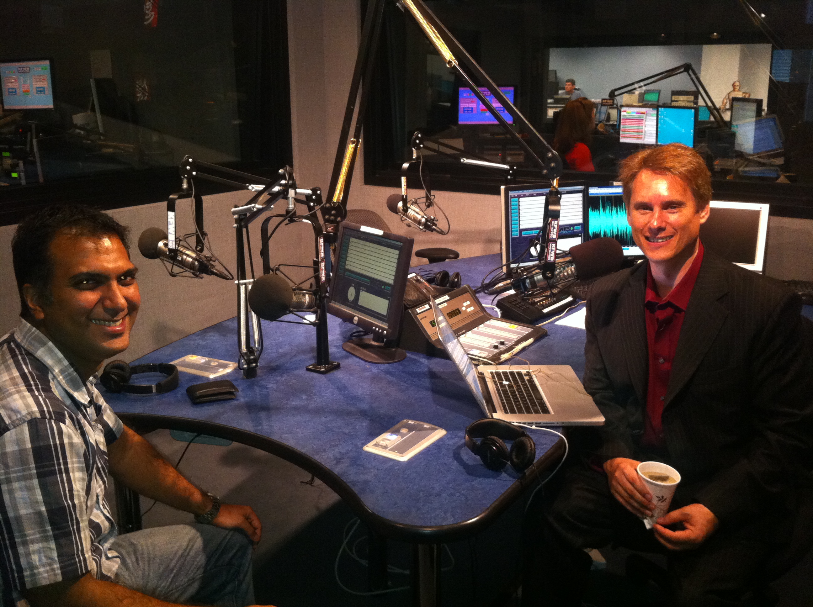 Sameer Bhatia, left, seated with Ken Rutkowski beside microphones in the Business Rockstars radio studio