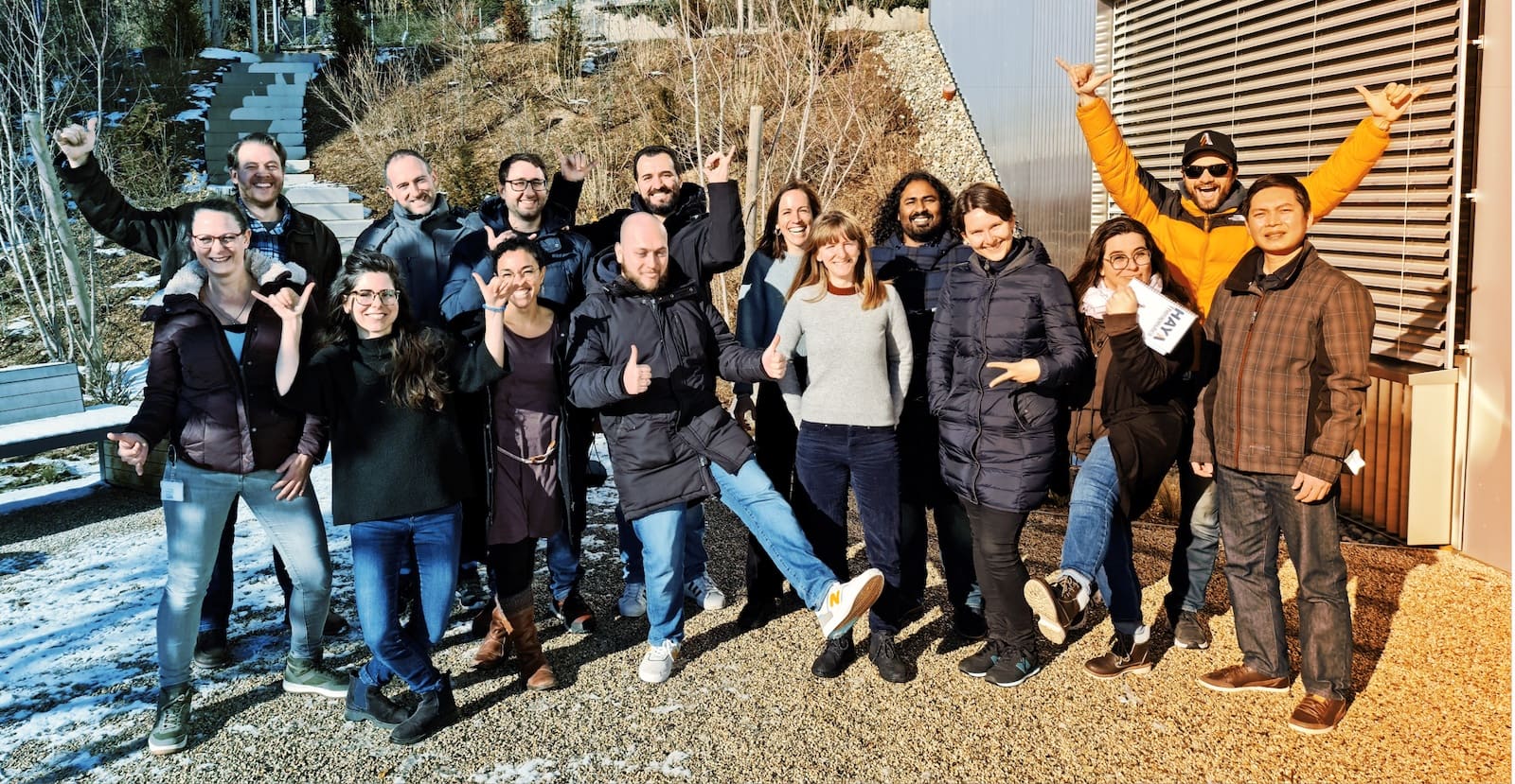 HAYA colleagues smiling and waving together outside a building