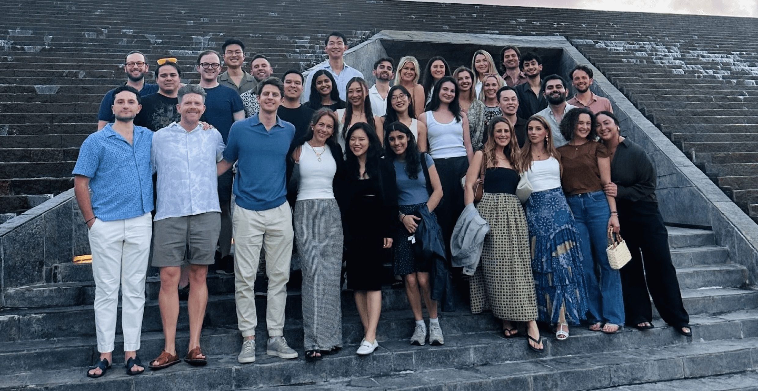 Members of the Fay team gathered on a broad outdoor staircase
