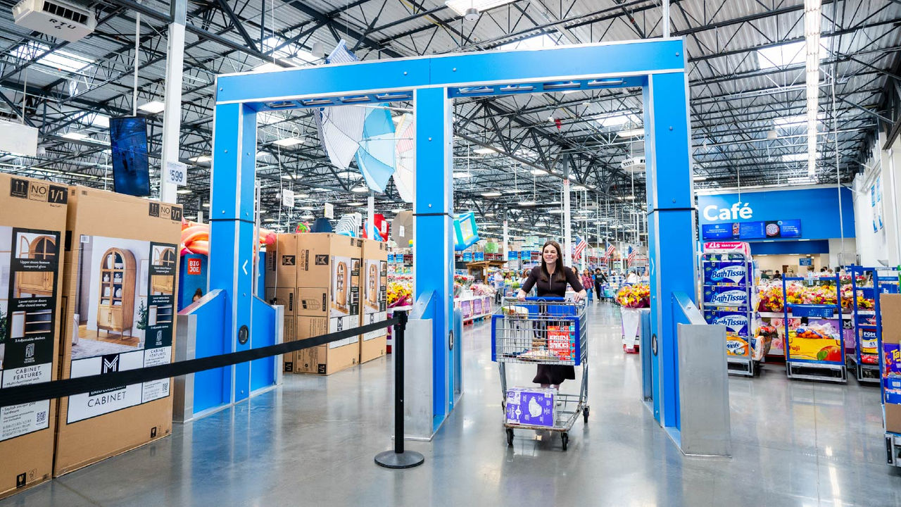 A Sam’s Club member pushes a shopping cart through an automated exit