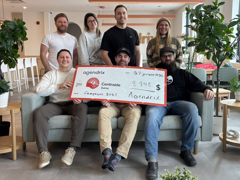 Seven Agendrix colleagues pose with a Centraide Estrie fundraising cheque; Samuel Roy is seated at left in the front row.