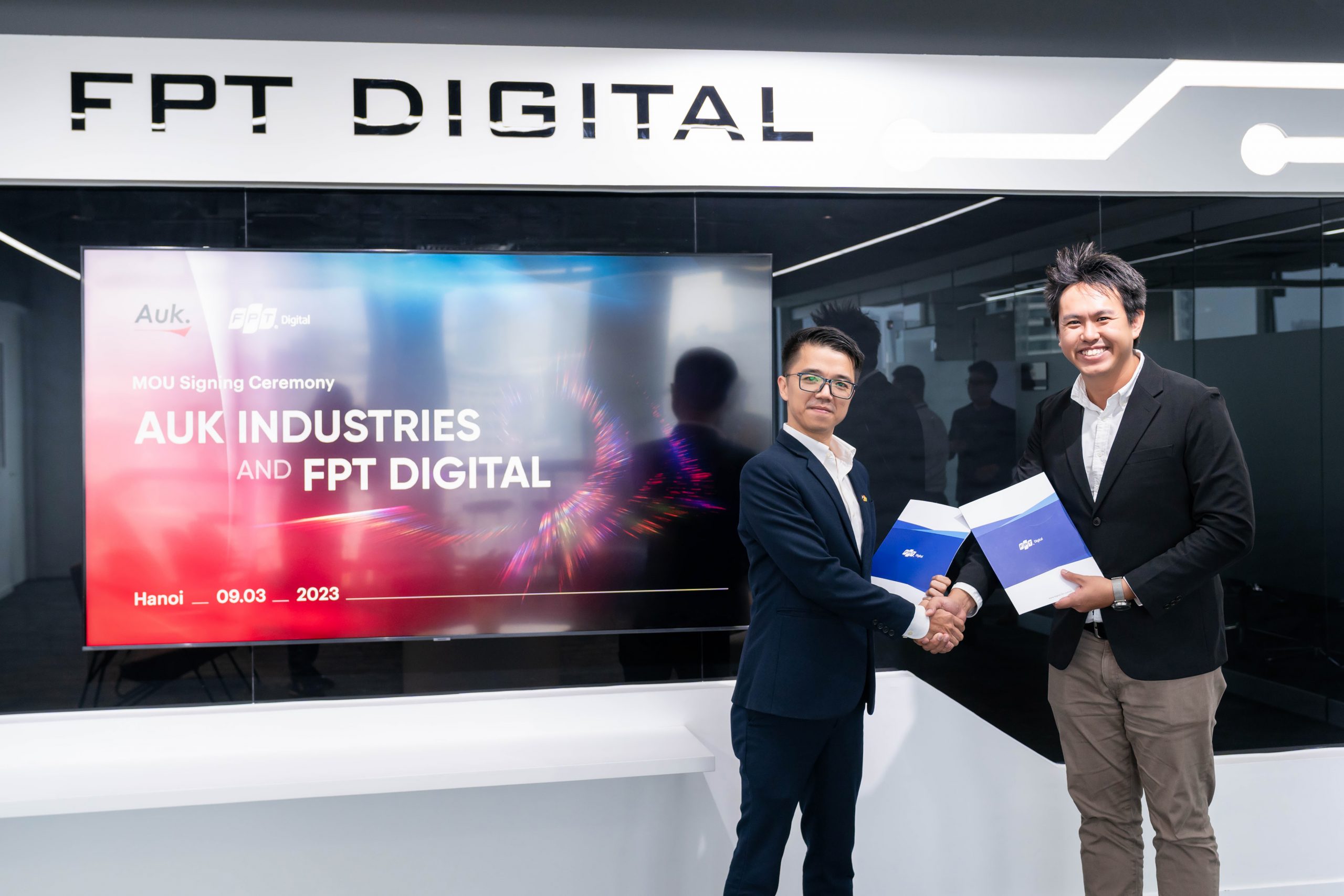 Samuel Tan at right shakes hands with Le Hung Cuong at the FPT Digital and Auk Industries signing in Hanoi