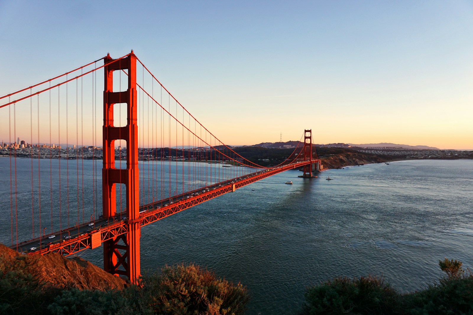 Golden Gate Bridge spanning the water toward San Francisco in warm light