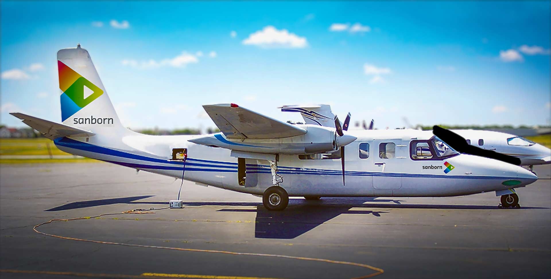 Sanborn twin-engine aircraft parked on an airfield