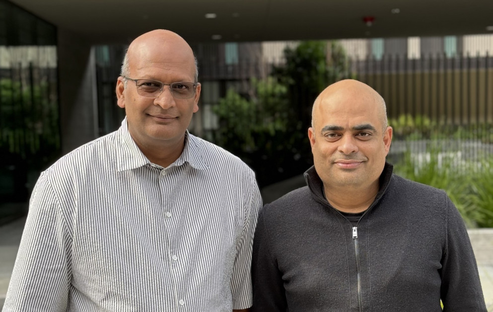 Auxia co-founders Ravi Desu, left, and Sandeep Menon, right, standing outside an office
