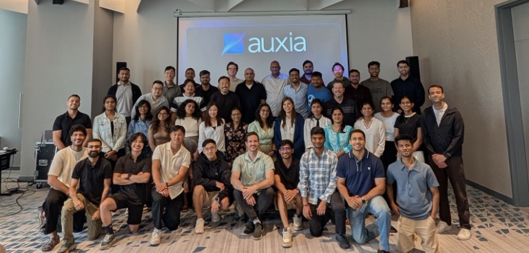 The Auxia team gathered in rows for a group photograph