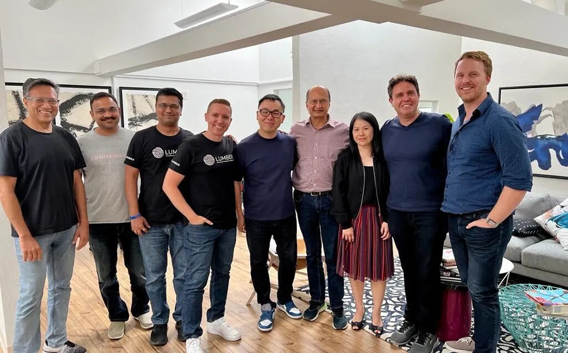 Sandeep Yeole standing with eight Lumber colleagues in an office
