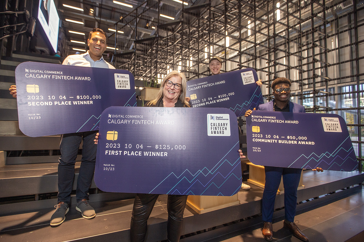 Sandi Gilbert stands at the centre of the 2023 Calgary Fintech Awards winners, holding DealPoint’s $125,000 first-prize cheque.