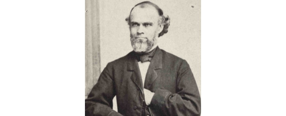 Historical portrait of Henry Varnum Poor, seated with his arms folded