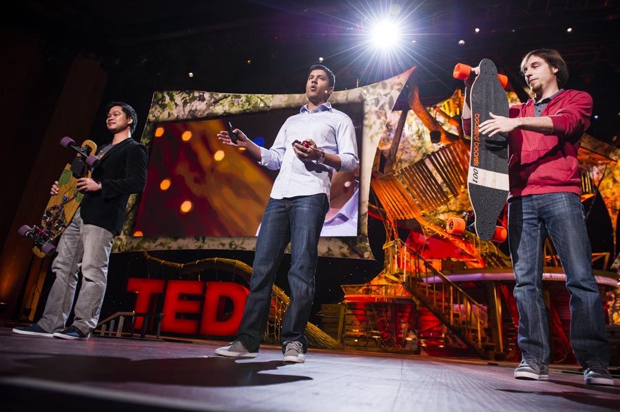 Sanjay Dastoor on the TED2013 stage with his Boosted co-founders and electric longboards