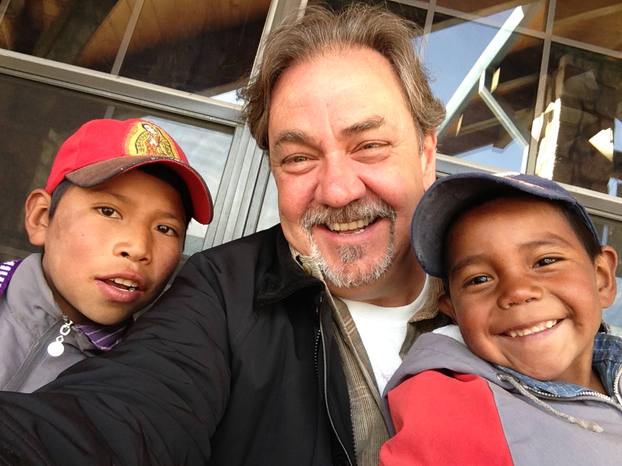 Santiago Pozo smiles at the center of a candid photograph with two other people.