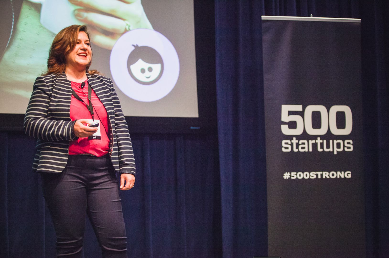 Sara Schaer presenting onstage beside a 500 Startups banner