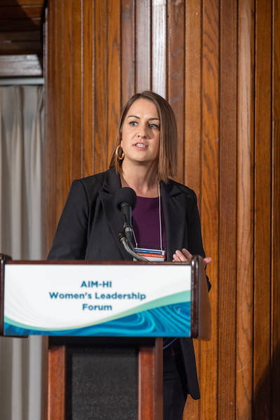 Sarah Hein speaking at a lectern during the 2023 AIM-HI Women’s Leadership Forum