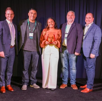 Five Compliance Group team members posing with an award at an event
