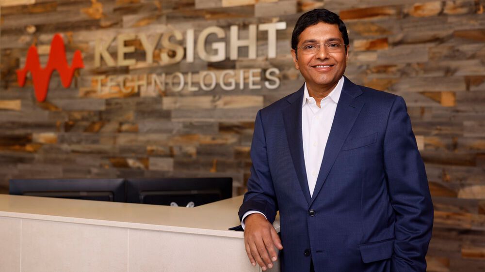 Satish Dhanasekaran standing beside a Keysight Technologies reception desk