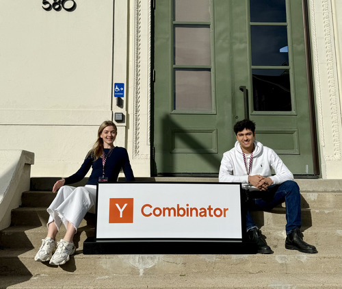 FuseAI co-founders Imogen Low and Saurav Bubber sitting beside a Y Combinator sign