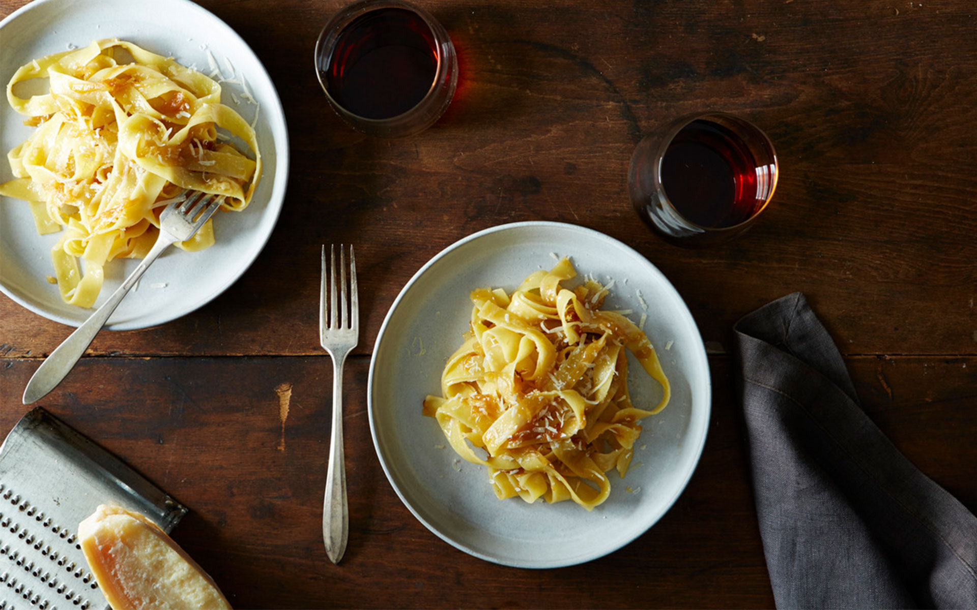 Pasta and wine on a dark dining table