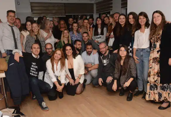 A group of Scopic team members gathered together indoors