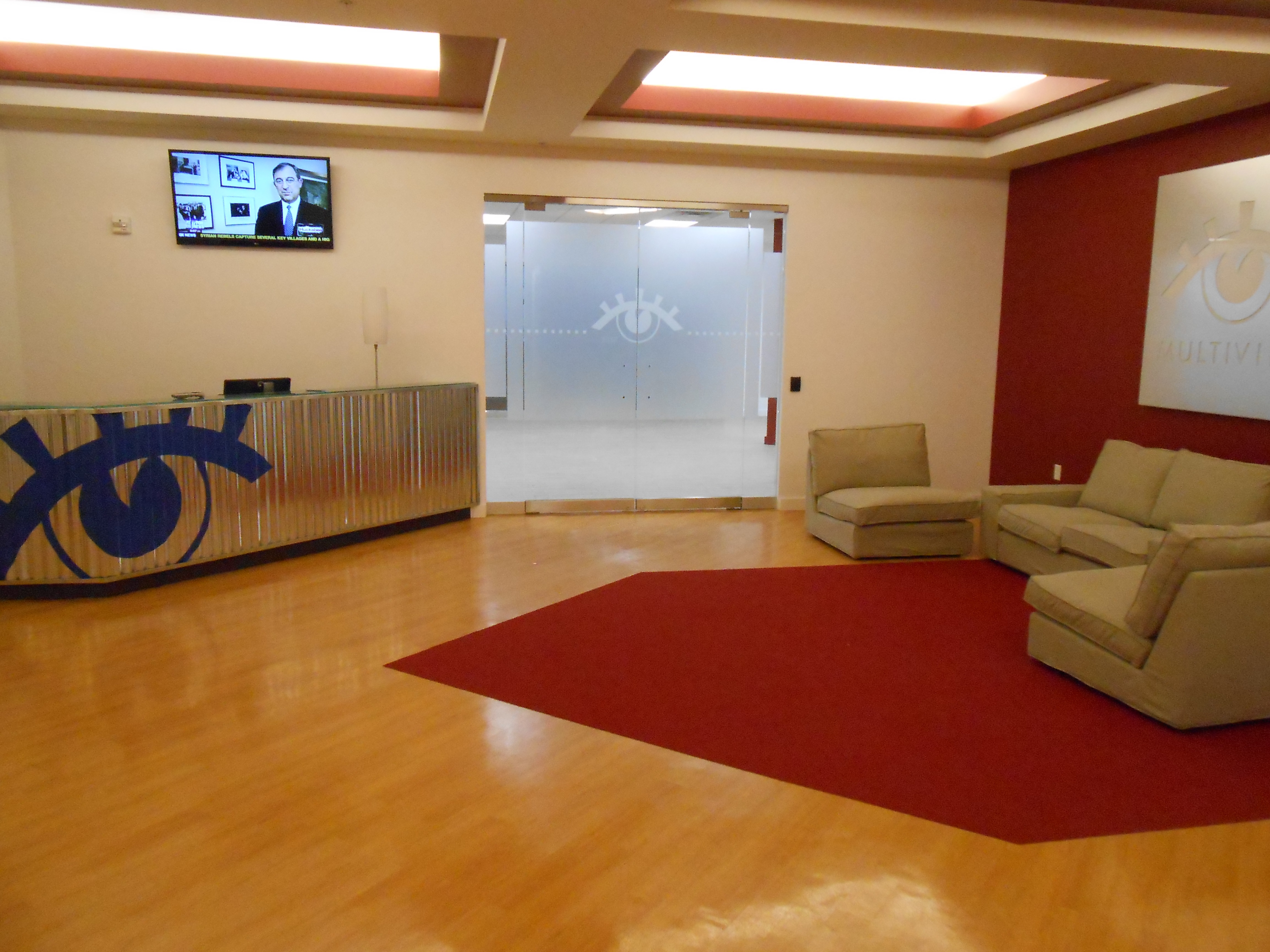 A Multiview office lobby with a reception desk, glass doors and lounge seating