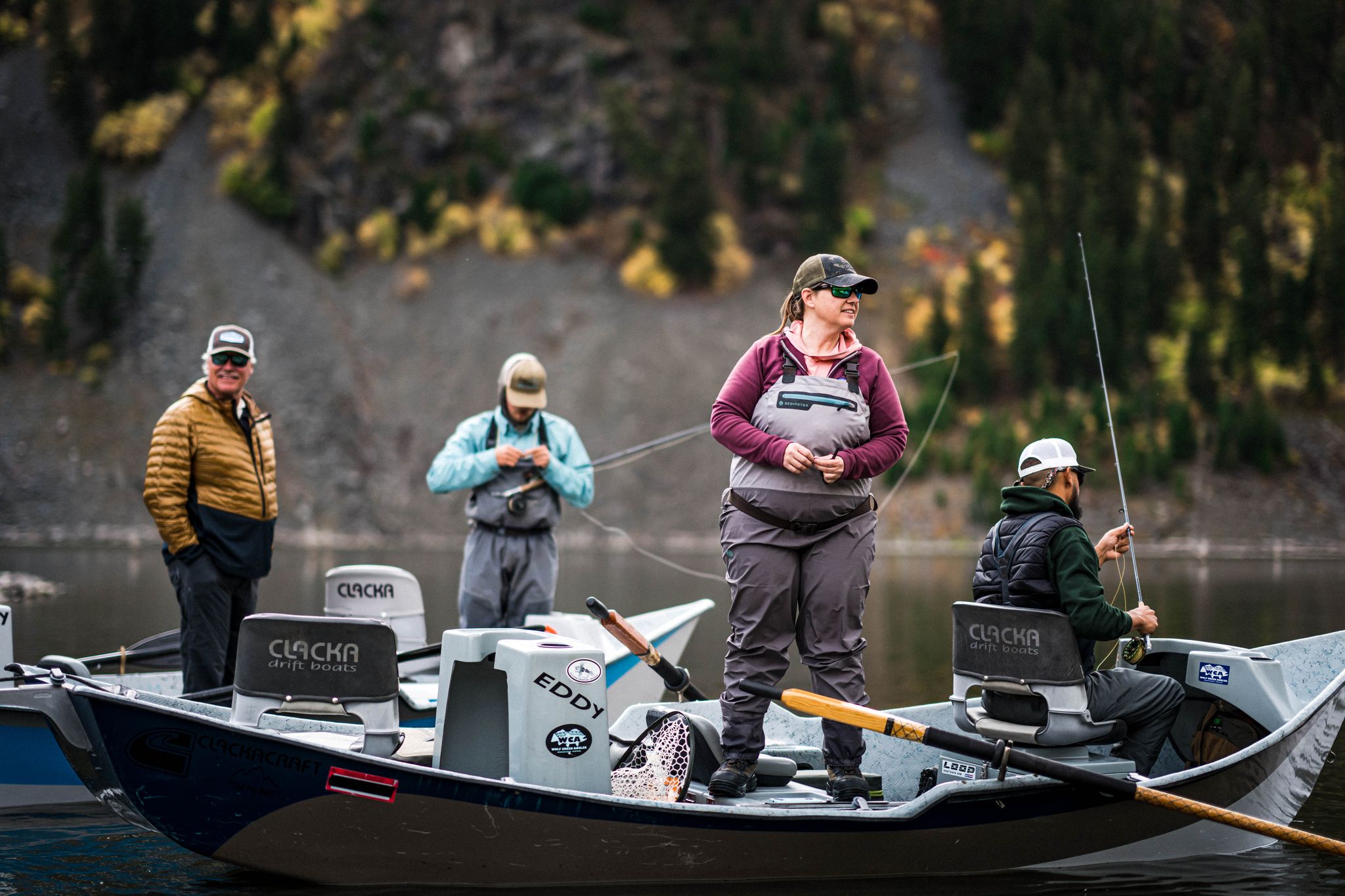 Scott Carver, at left in a gold jacket, with anglers and drift boats on the river