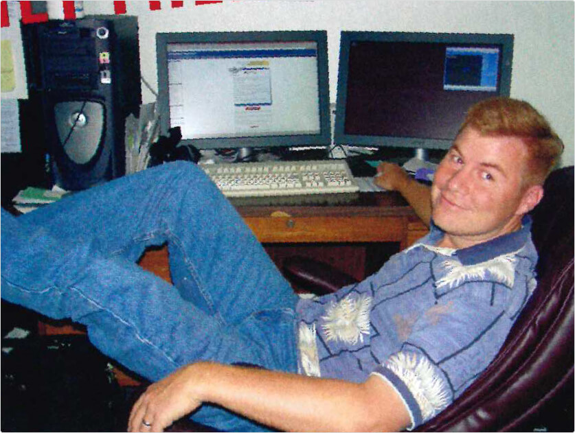Scott Moscrip reclining in an office chair beside his computers in a company archive photograph labelled 1995