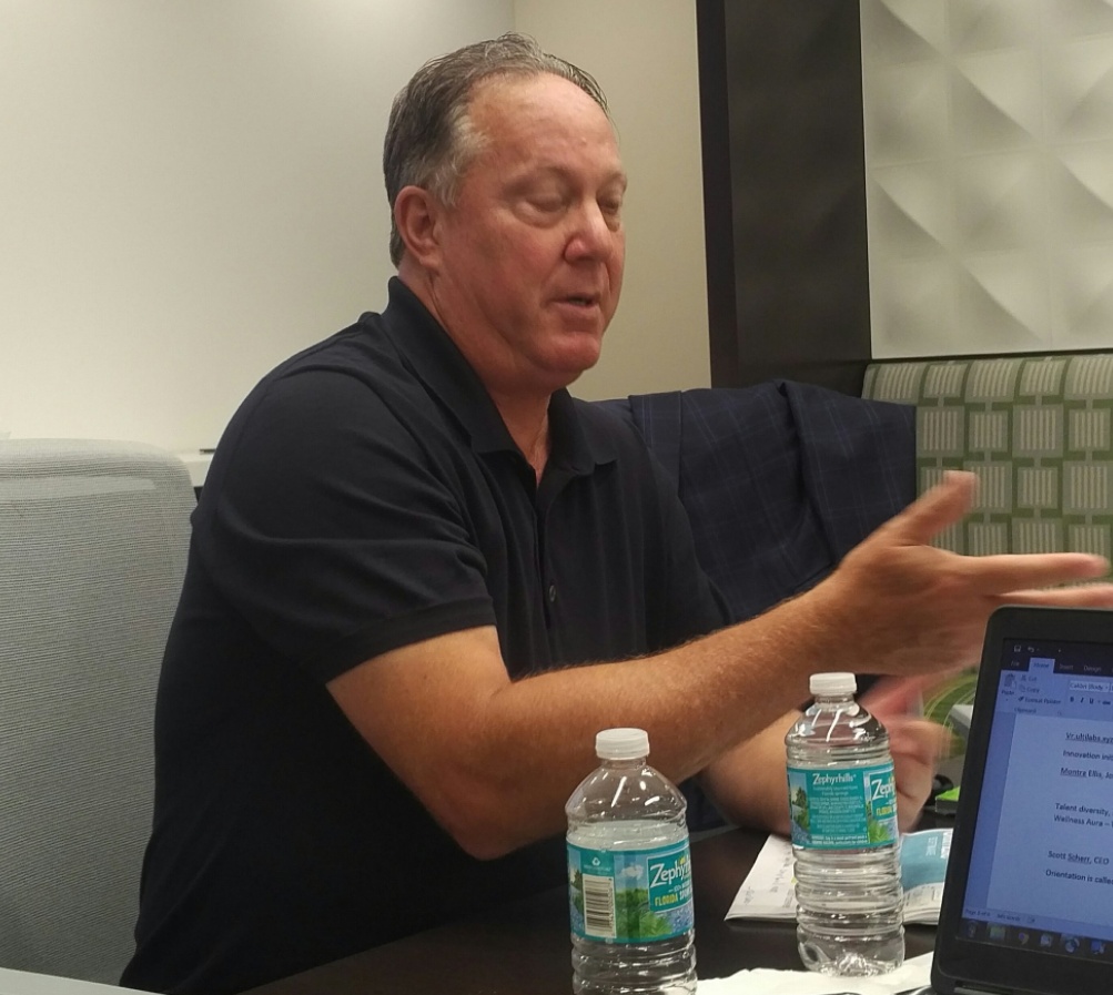 Scott Scherr speaking with analysts around a conference table at Ultimate Software in 2017