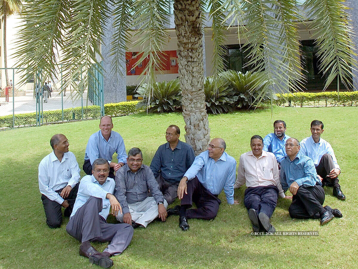 Mindtree's ten co-founders gathered outdoors on a lawn, including Scott Staples in a light blue shirt near the left