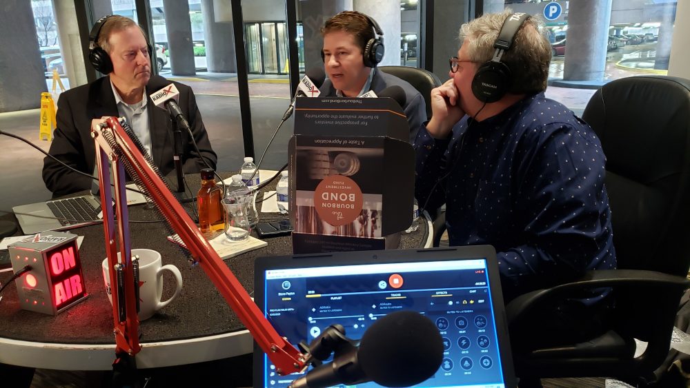 Scott Unger and fellow guests wearing headphones at an Atlanta Business Radio recording table