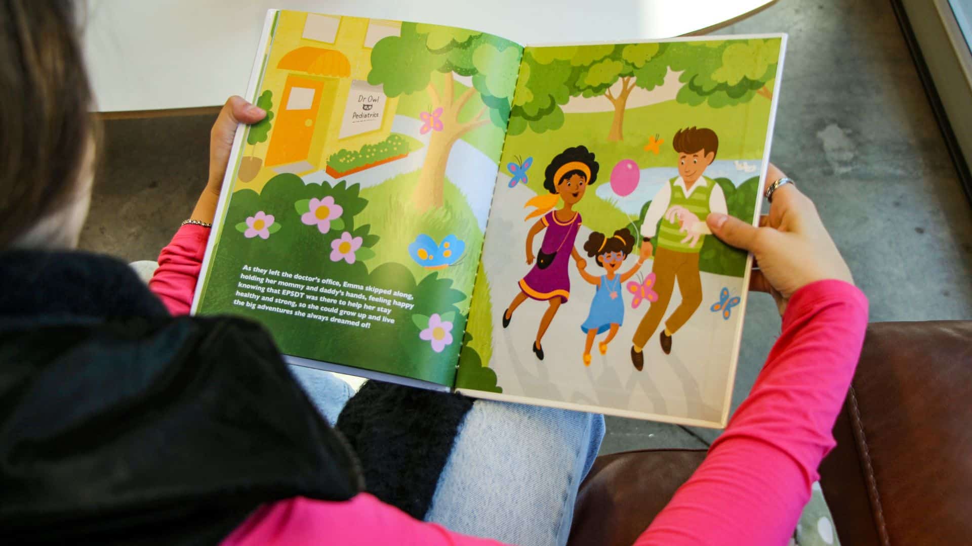 A reader holding an illustrated children's book made for a Medicaid outreach campaign