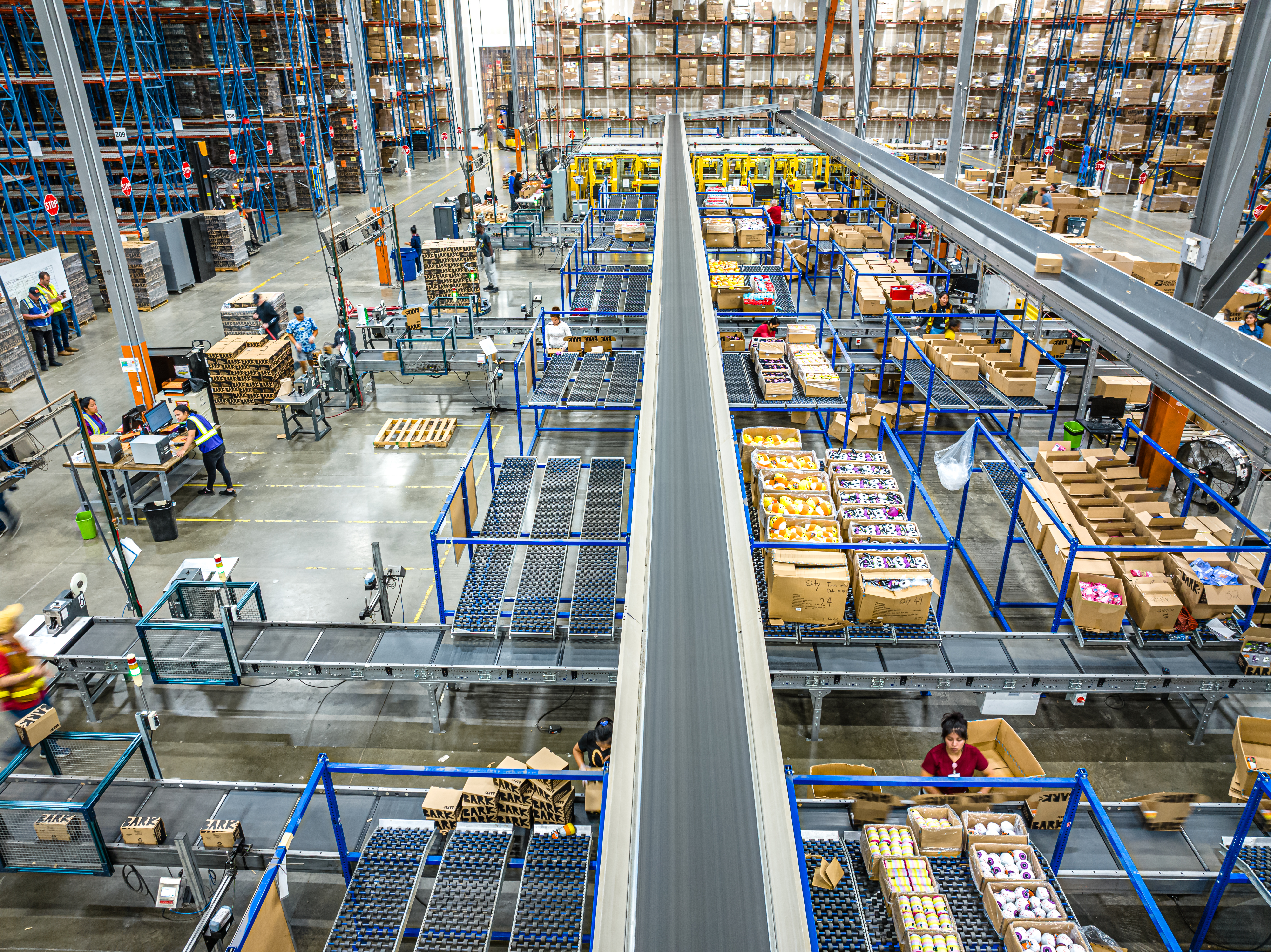 A wide view of a Stord fulfillment floor with conveyors, storage racks and workers processing packages