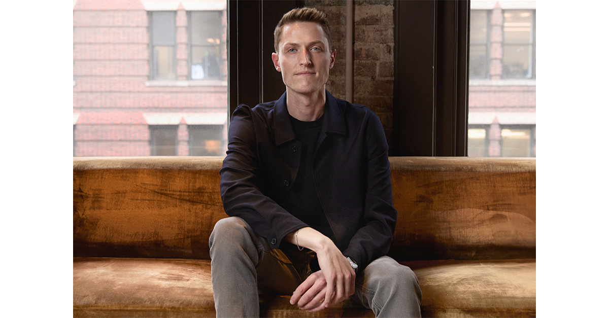 Sean Henry seated on a brown velvet sofa in Atlanta