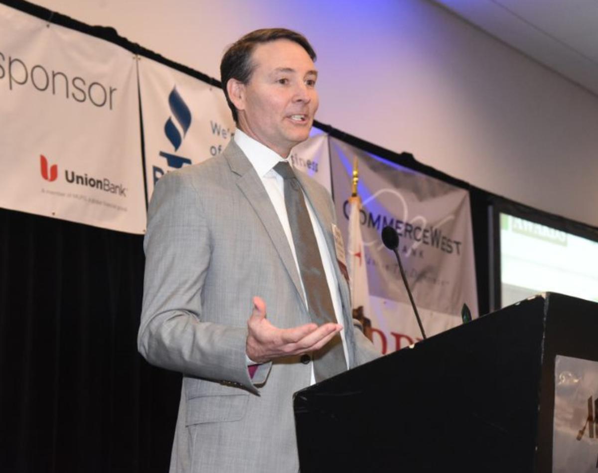 Sean McCloskey speaking at a lectern during a business event
