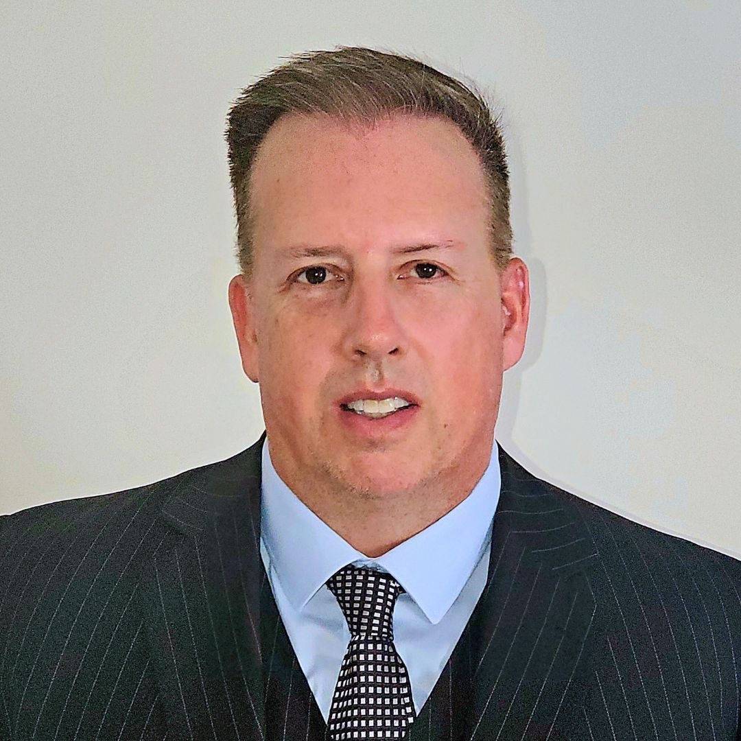 Sean Murphy in a pinstripe suit, photographed for Elite’s appointment announcement