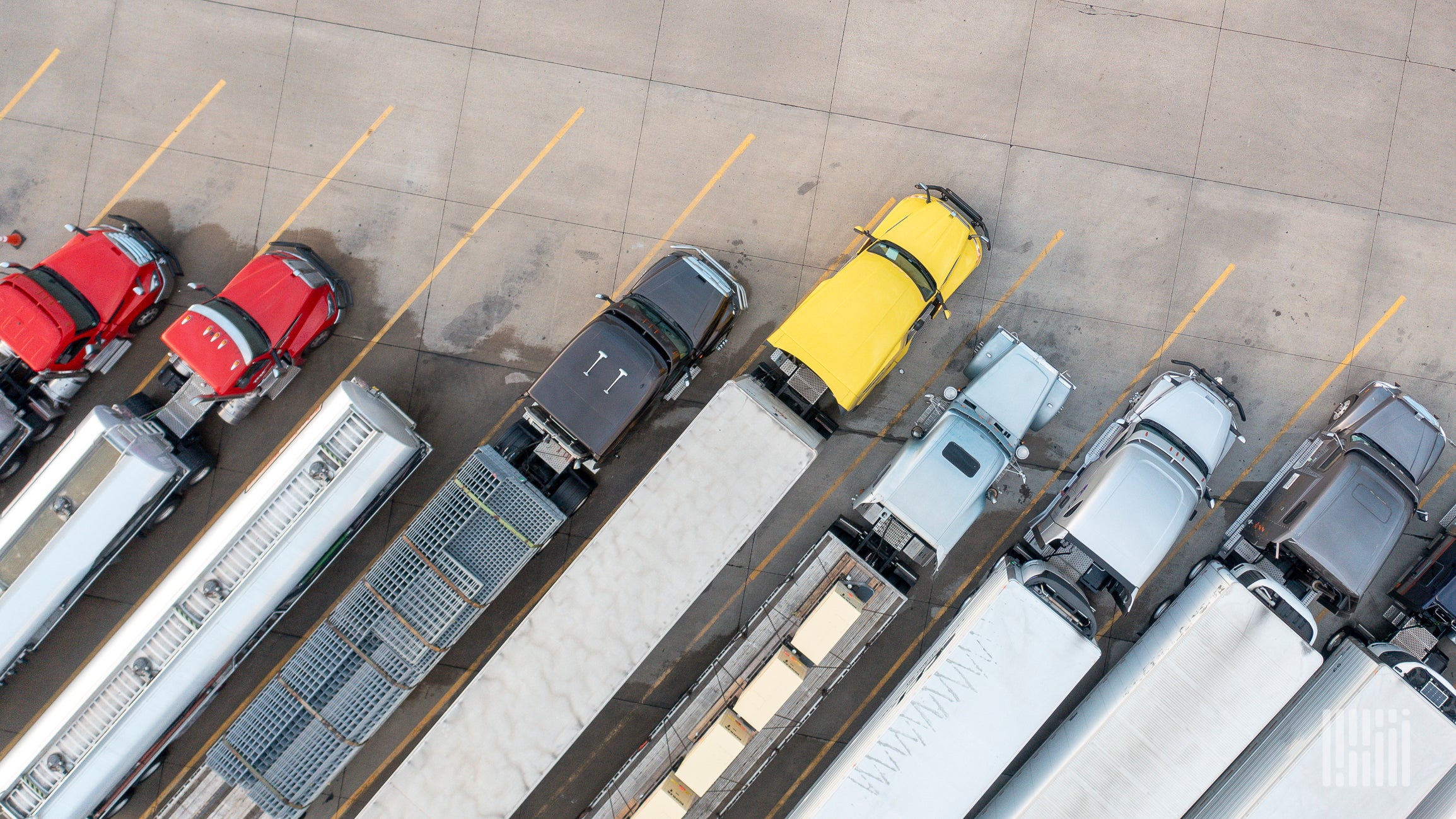 An aerial view of freight trucks parked in angled rows