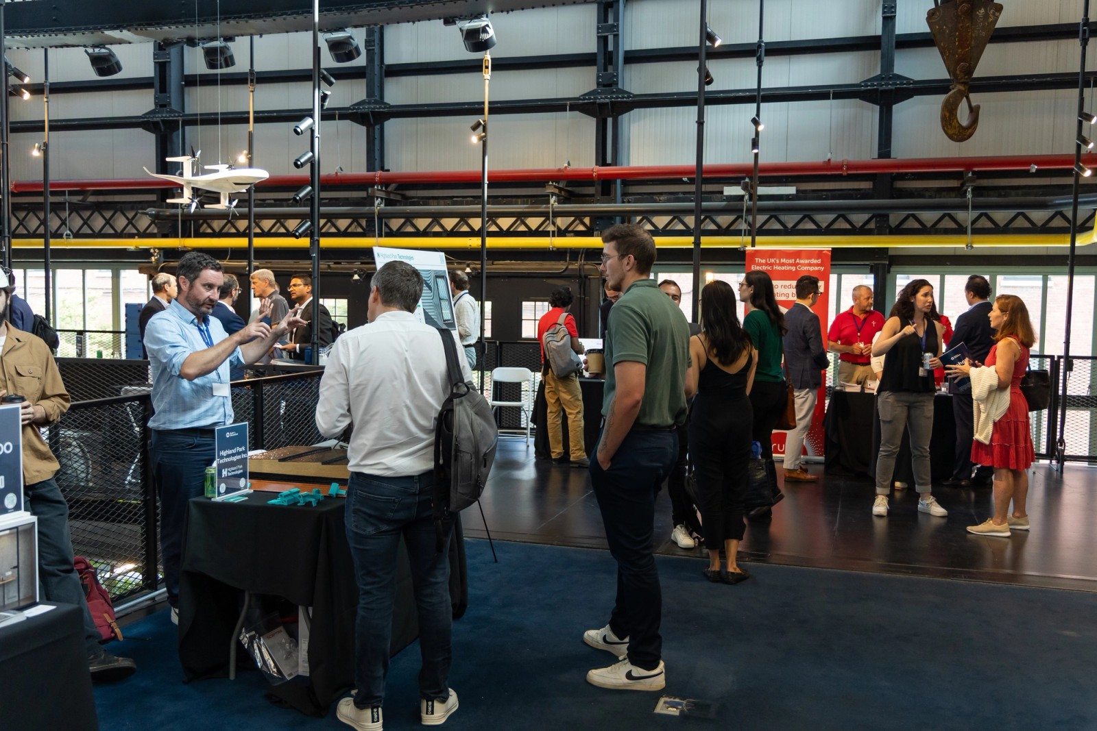 Participants talking beside technology exhibits at an industry event
