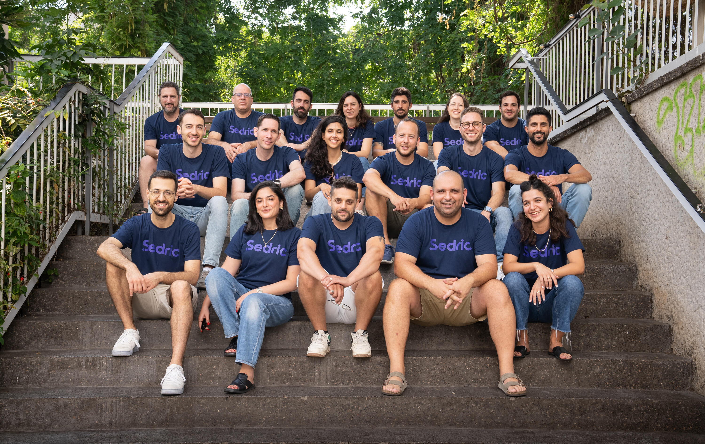 Members of the Sedric team gathered outdoors wearing company shirts