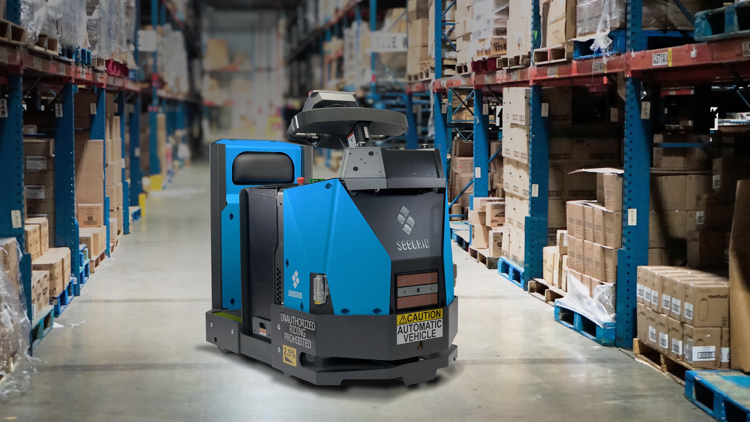 Blue Seegrid autonomous tow tractor in an aisle between loaded warehouse racks
